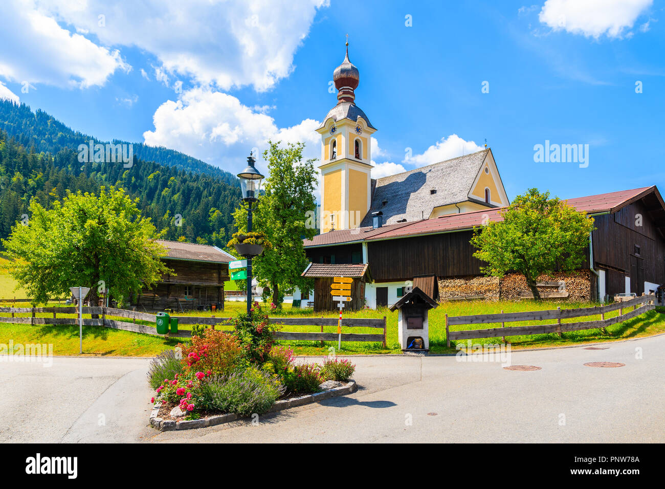 Iglesia en verde prado en ir am Wilden Kaiser aldea de montaña en un día soleado de verano, Tirol, Austria Foto de stock