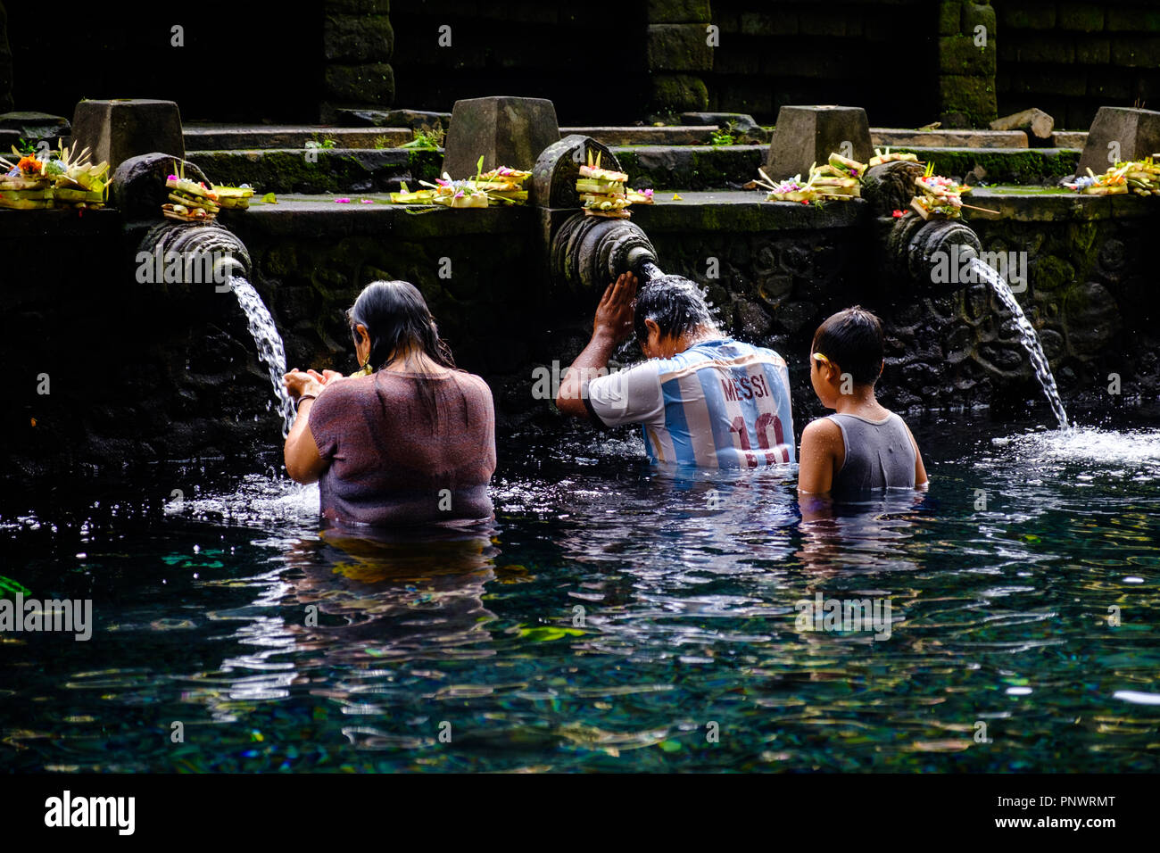 Las personas que toman un ritual balinés baño purificador de agua de  manantial santo en pura Tirta Empul Fotografía de stock - Alamy