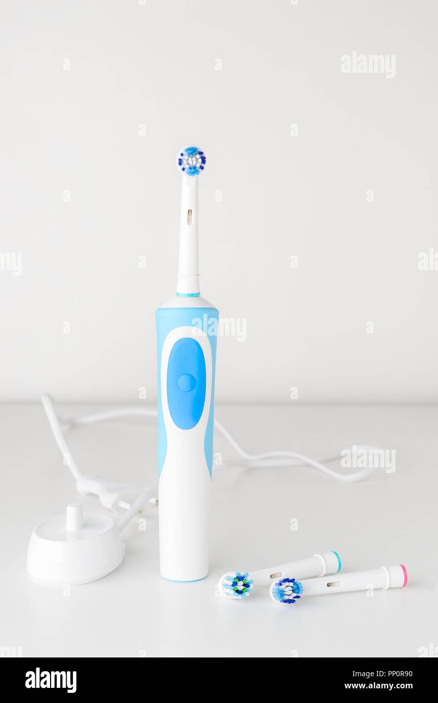 Cepillo dental eléctrico y cabezales de cepillo de repuesto sobre fondo blanco, cerrar Foto de stock