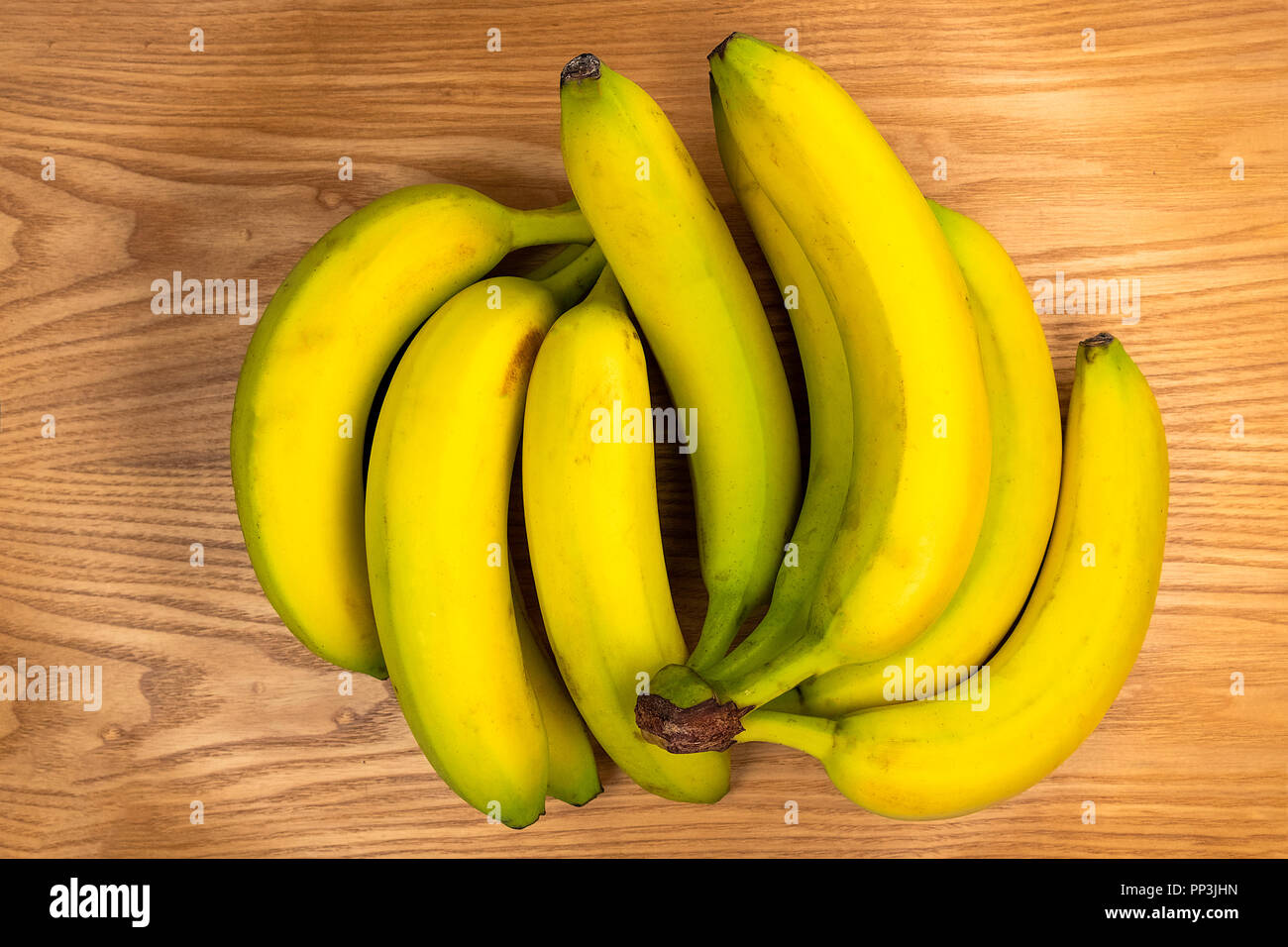 Los plátanos en una placa de madera Foto de stock