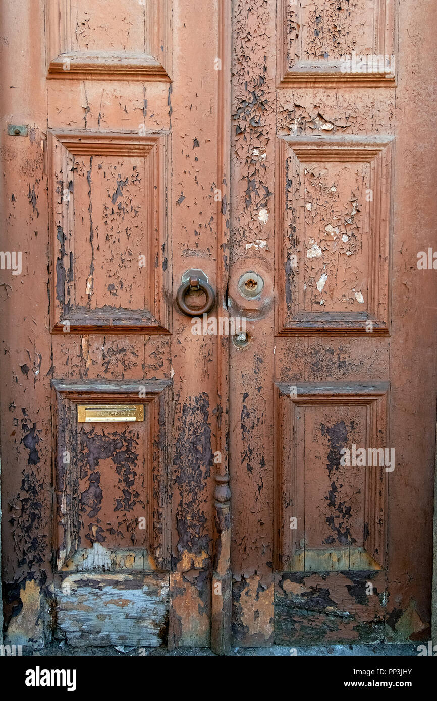 Antigua puerta con peeling desapareció la pintura y el martinete de hierro oxidado. Foto de stock
