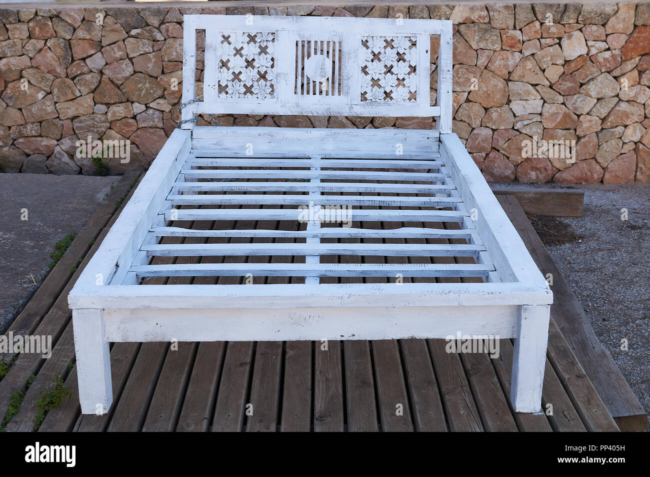 Antigua cama de madera blanca en el porche de entrada de Can director Xicu  vintage shop en el Pilar de La Mola (La Mola, Formentera, Islas Baleares,  España Fotografía de stock -