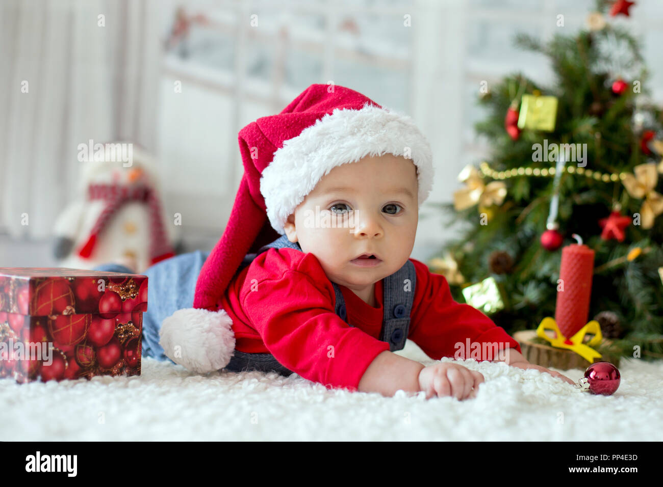 Retrato de bebé recién nacido en Santa ropa y sombrero de navidad, tumbado  en el suelo, la nieve del invierno paisaje exterior Fotografía de stock -  Alamy