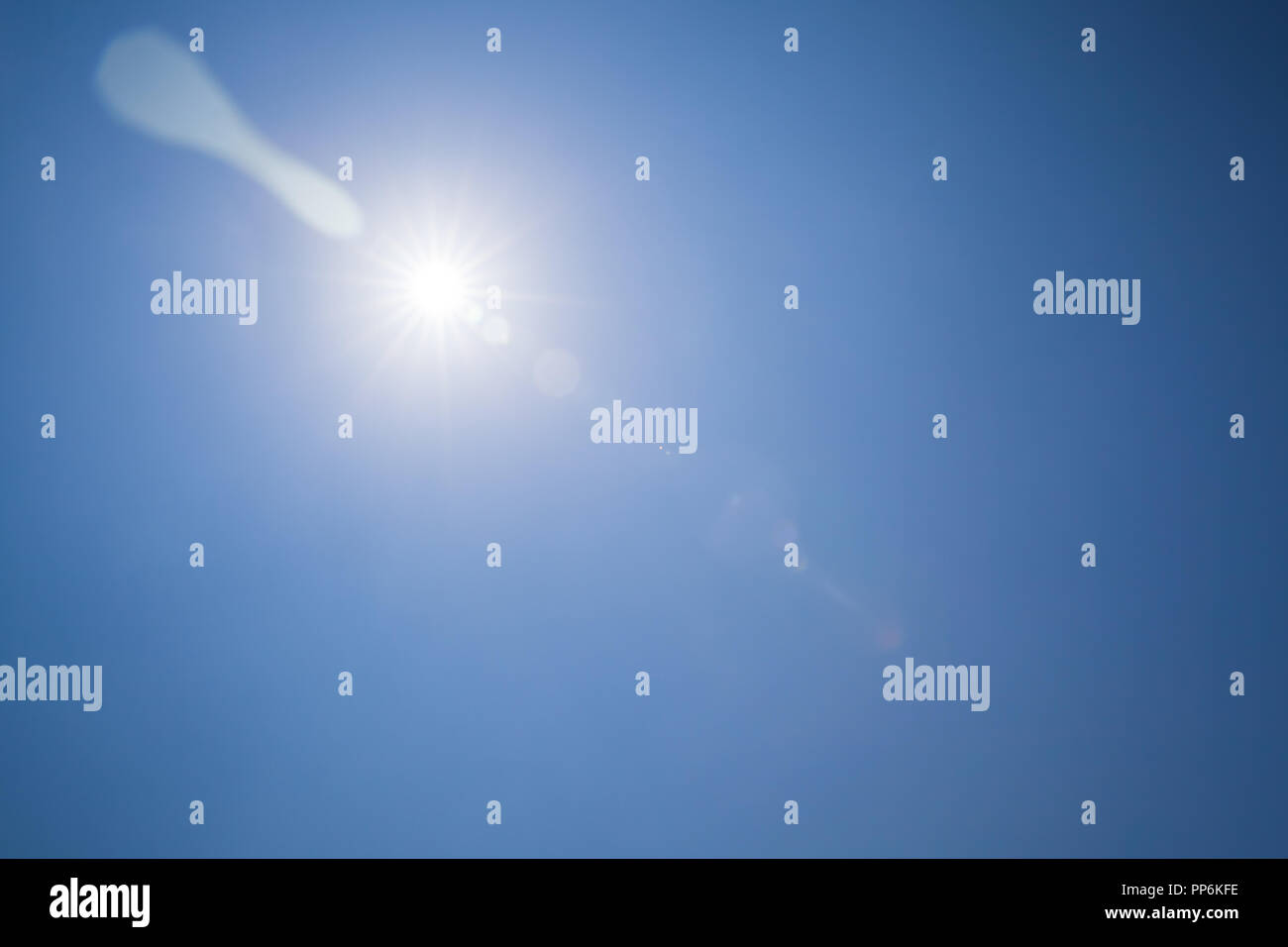 Efecto Destello de lente sobre el cielo azul con sol radiante Foto de stock