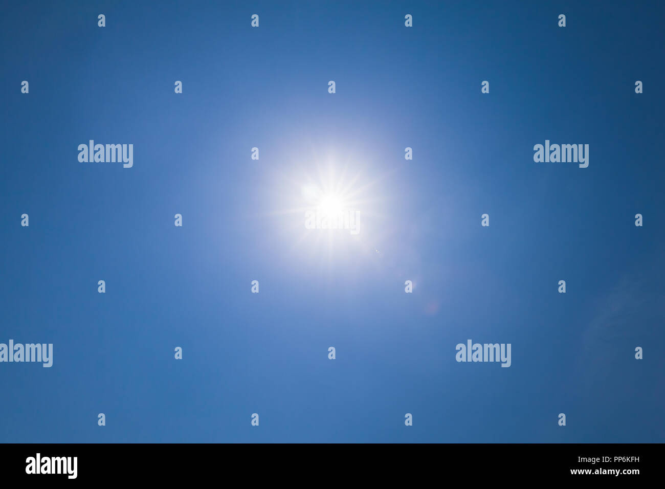 Destello de lente, efecto óptico sobre el cielo azul con la luz del sol Foto de stock
