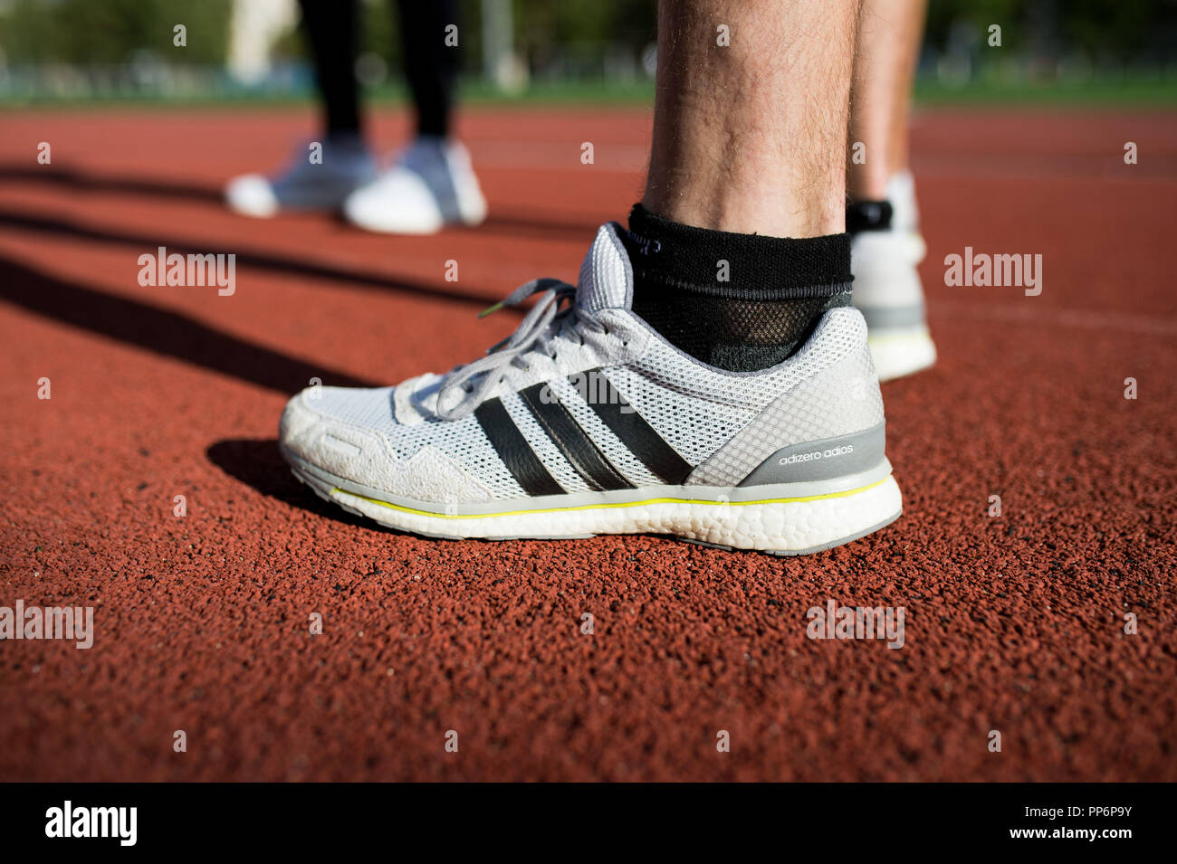 Ejecutar: Adidas zapatos para en una pista de atletismo durante un entrenamiento de stock