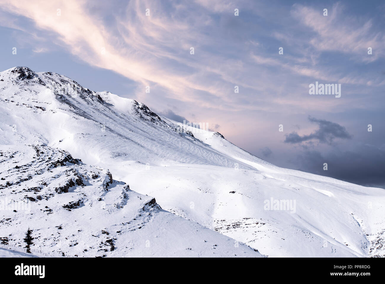 Paisaje invernal con montañas nevadas al atardecer. Foto de stock