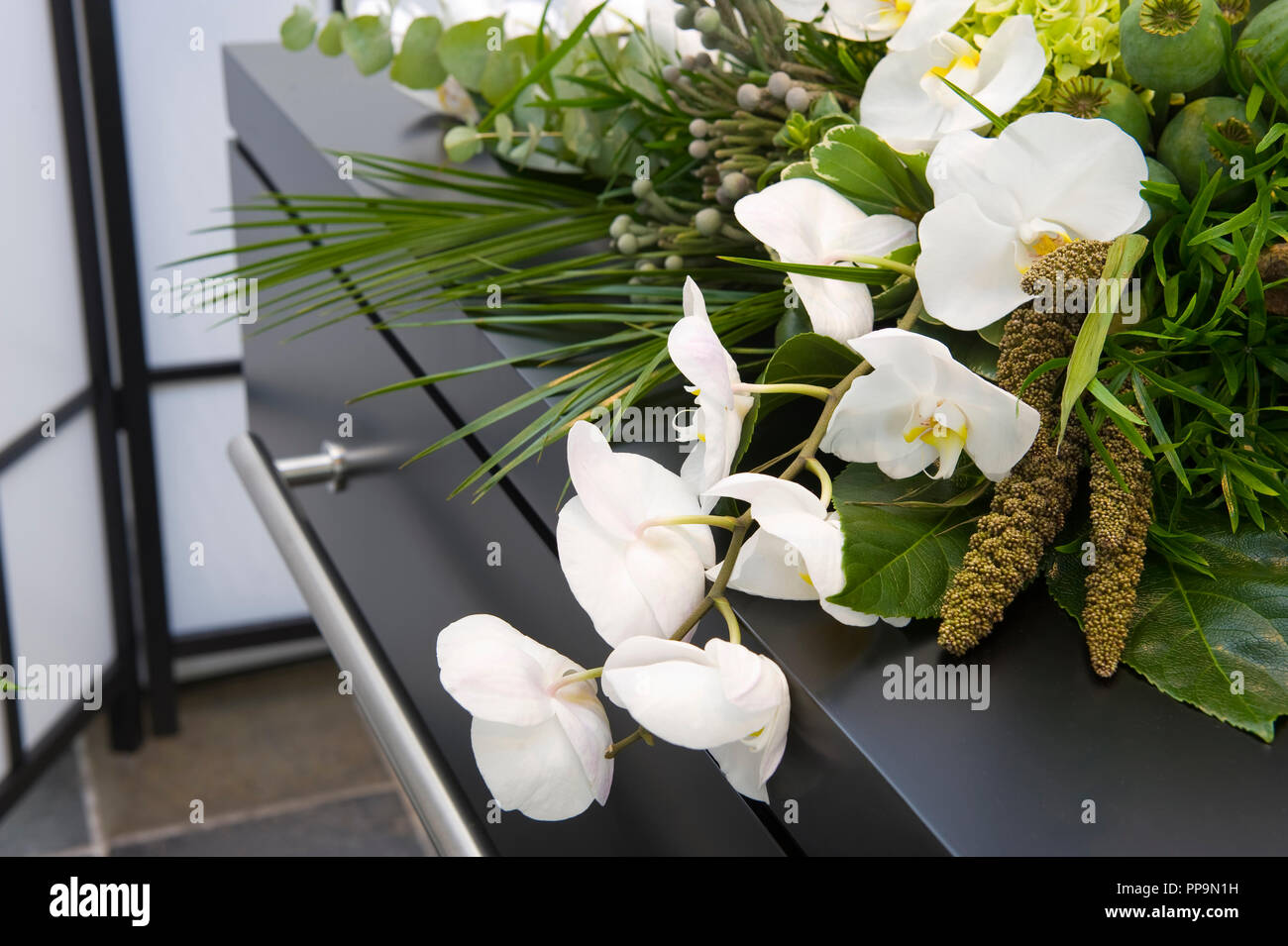 Un arreglo de flores en un ataúd en un depósito de cadáveres Foto de stock