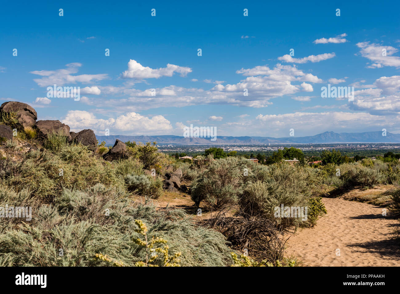 Vista de la ciudad de Albuquerque, paisaje y Montañas Sandia desde el sendero del Cañón Piedras Marcadas en el Monumento Nacional Petroglifo, Nuevo México EE.UU Foto de stock