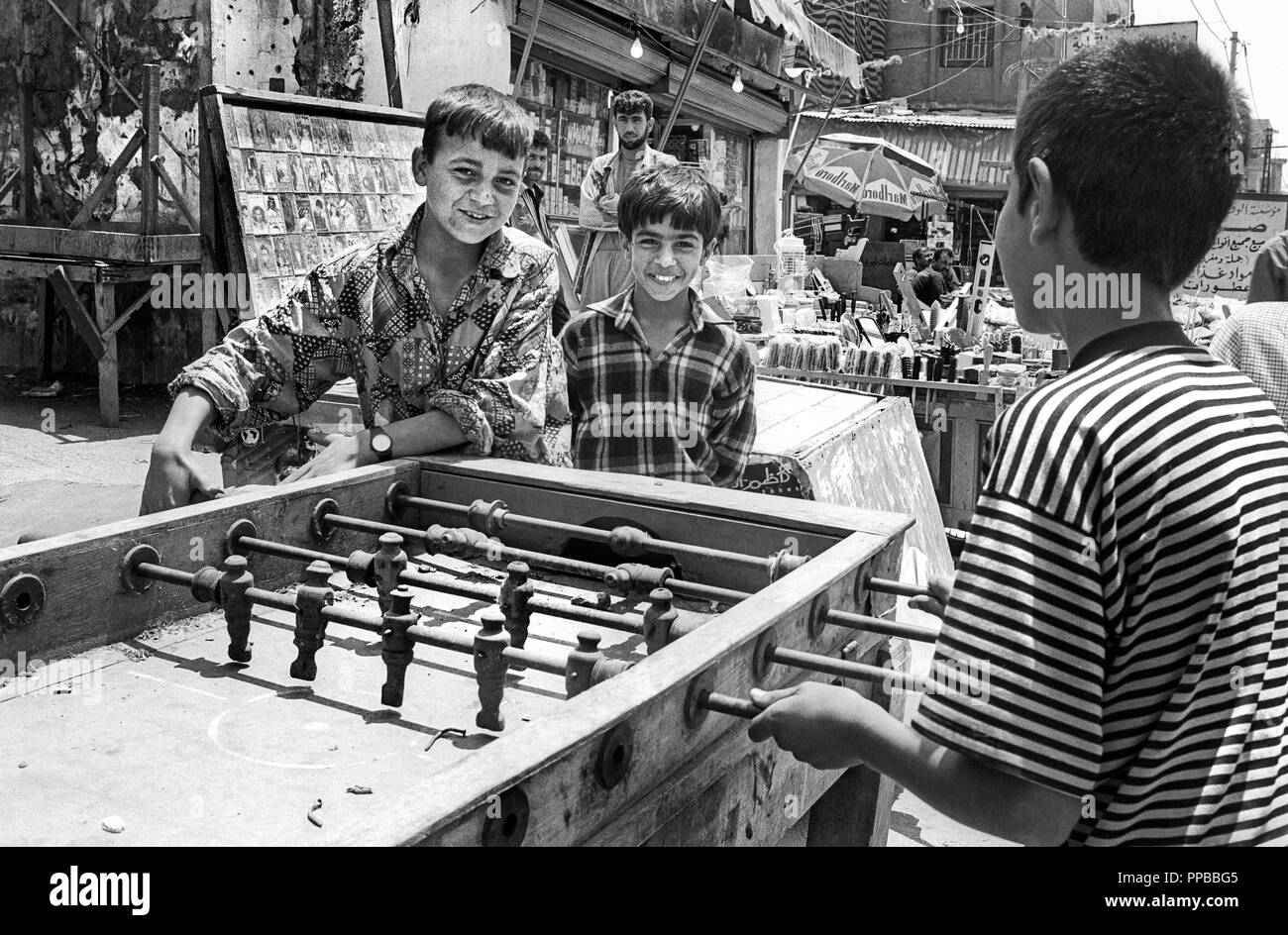 Un grupo de muchachos jugando fútbol de mesa. Los campamentos de refugiados palestinos de Sabra y Shatila, en Beirut, en el Líbano de 1998. Foto de stock