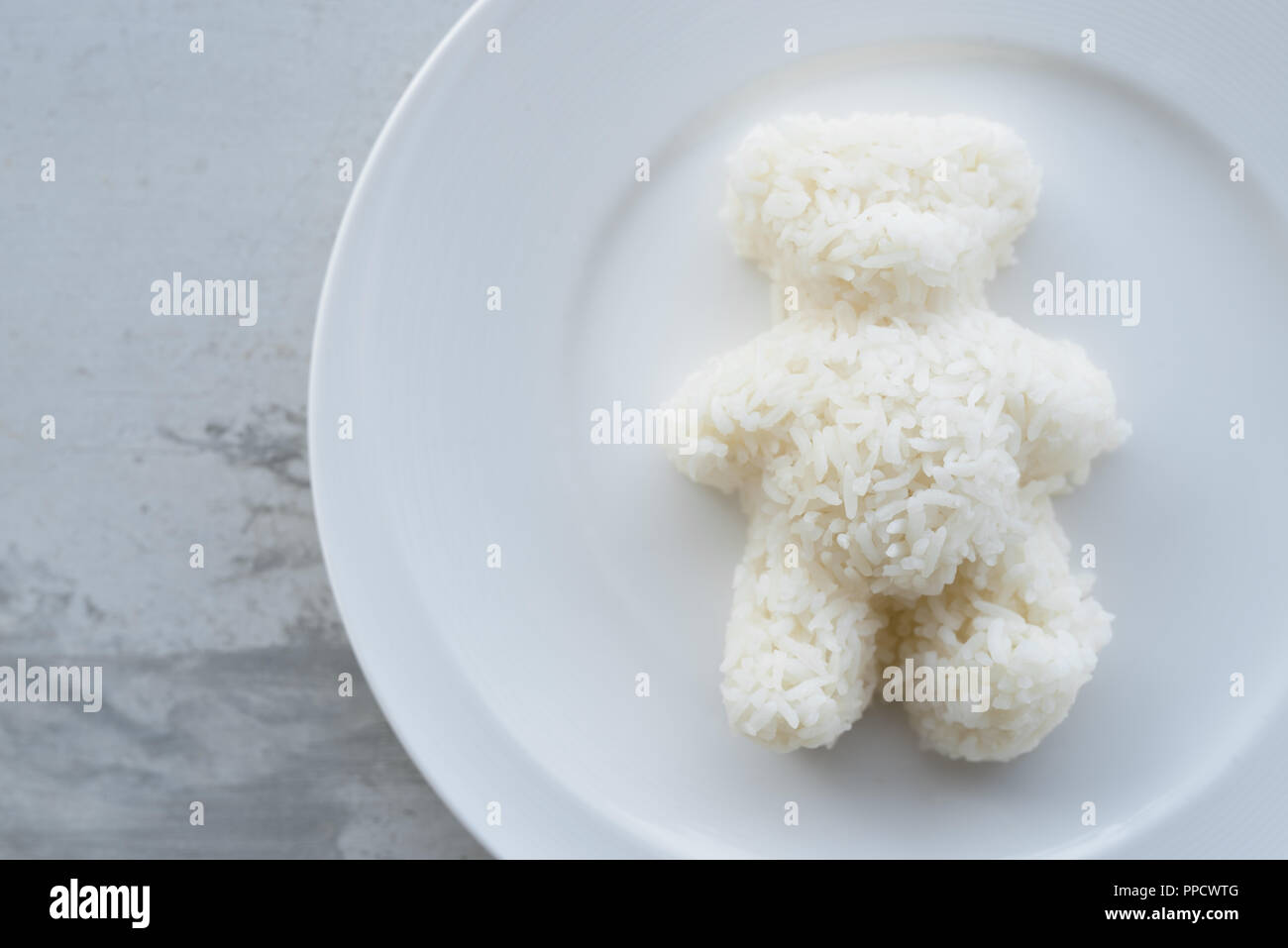 Oso de peluche en forma de arroz blanco cocido servido en la placa blanca. Foto de stock