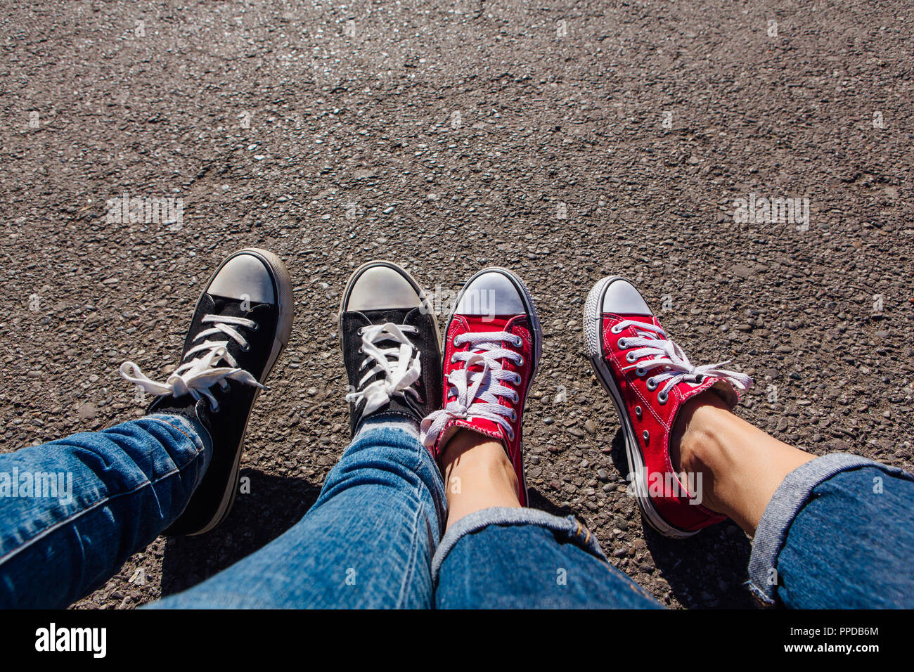 más lejos Bebé Parcialmente Rojo y negro zapatillas zapatos en los pies femeninos. Sneakers zapatos  pareja. Copie el espacio Fotografía de stock - Alamy