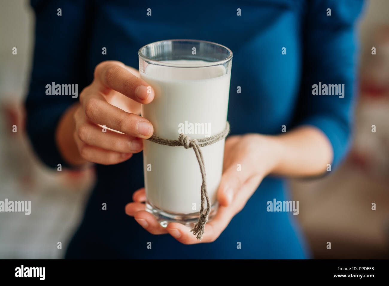 Mujer joven manos sosteniendo un vaso de leche. Foto de stock