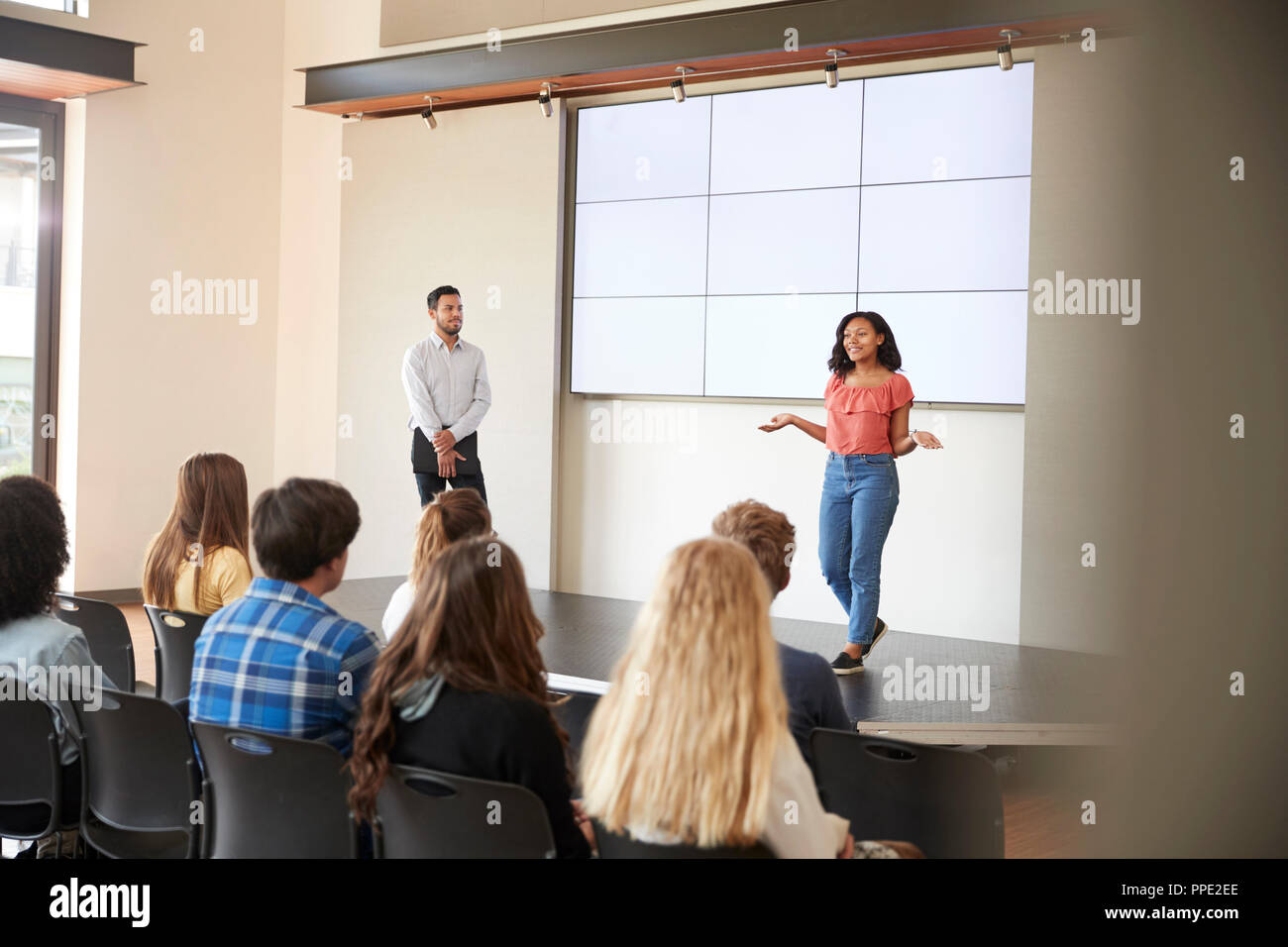 Estudiante femenina dando Presentación a clase en la escuela en la parte delantera de la pantalla Foto de stock