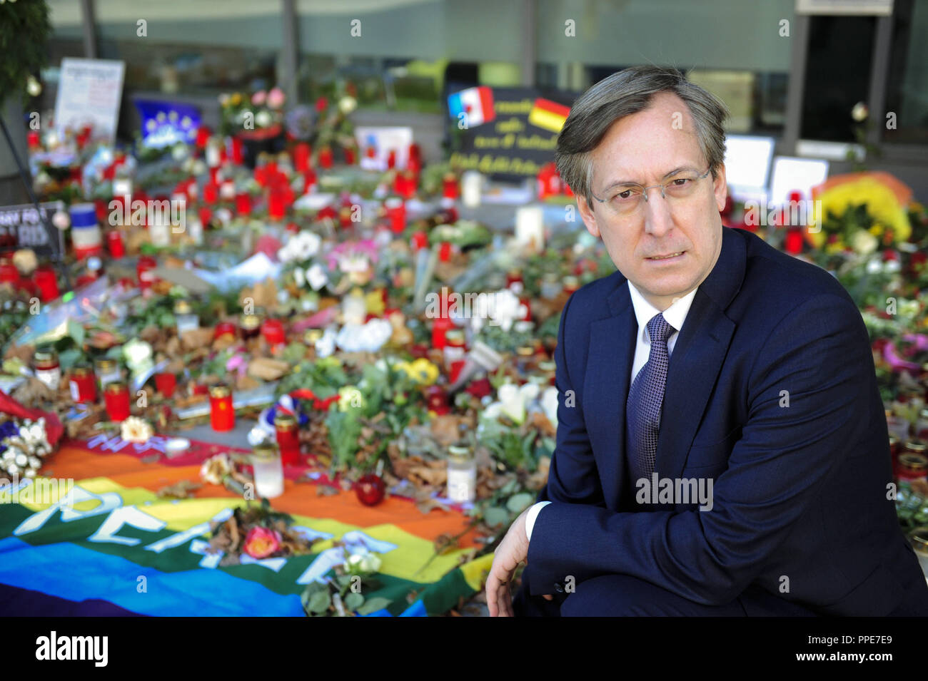 El Cónsul General francés Jean-Claude Brunet, está de luto por las víctimas de los ataques terroristas en París. En el fondo, los residentes de Munich depositó flores y velas ante el edificio del consulado en el Heimeranstrasse. Foto de stock