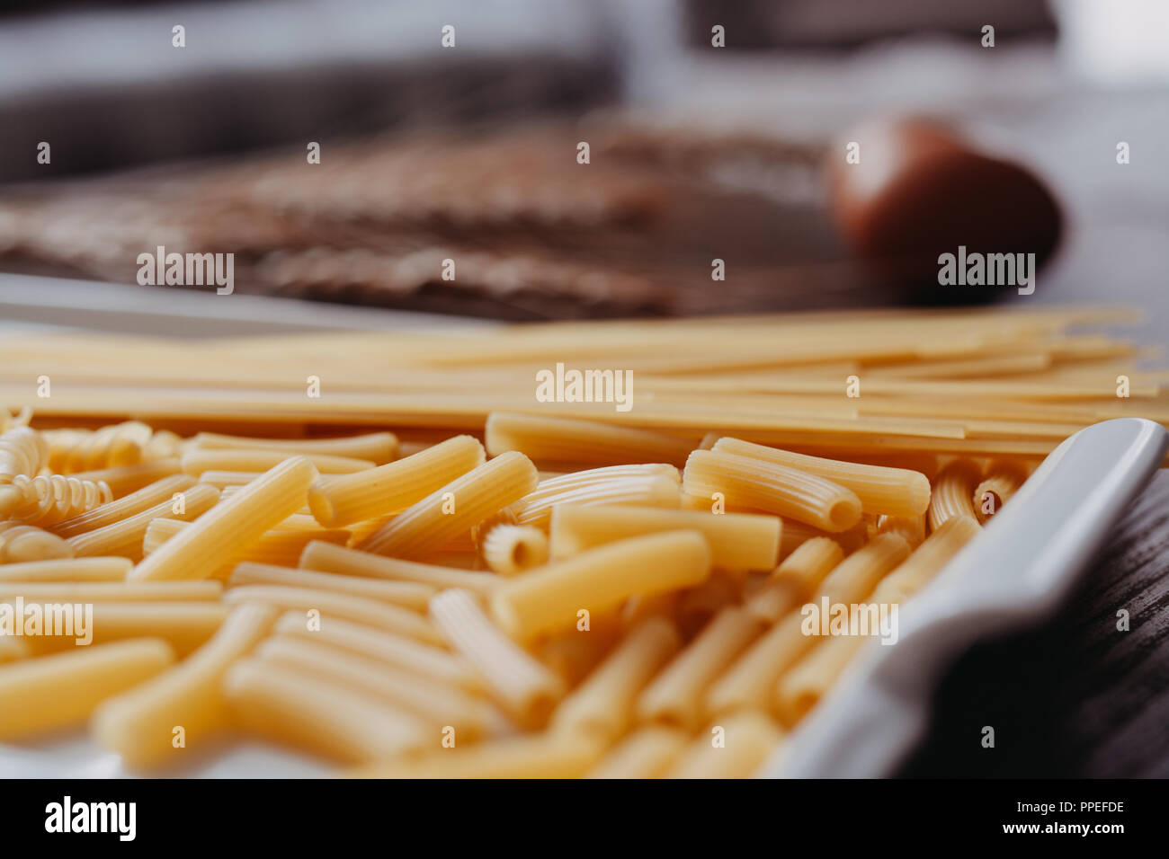 La pasta cruda en el fondo de madera de estilo rústico. Enfoque selectivo Foto de stock