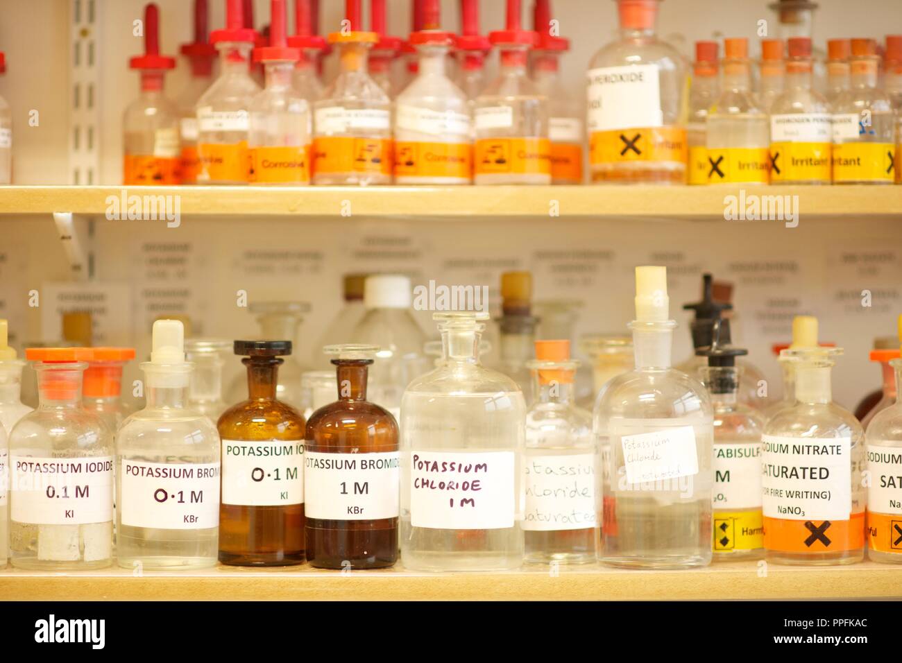 Botellas de chemcicals en estantes en un laboratorio de ciencia incluyendo el yoduro de potasio, cloruro de potasio, bromuro de potasio, nitrato de sodio, productos químicos Foto de stock