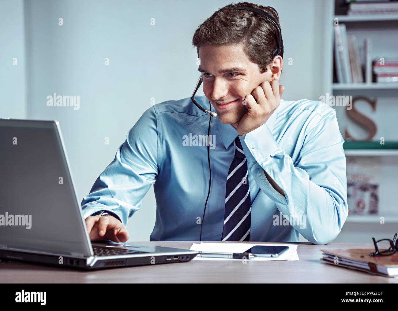 Manager hombre hablando por el teléfono y mira a la portátil. Foto de gerente de éxito trabajando con datos financieros en la oficina. Concepto de negocio Foto de stock
