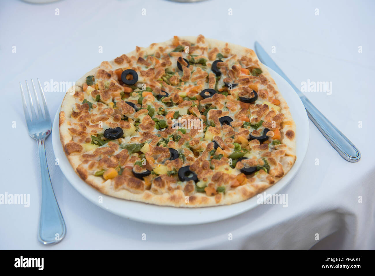 Pizza vegetariana vegetales mixtos en el restaurante al aire libre configuración de tabla Foto de stock