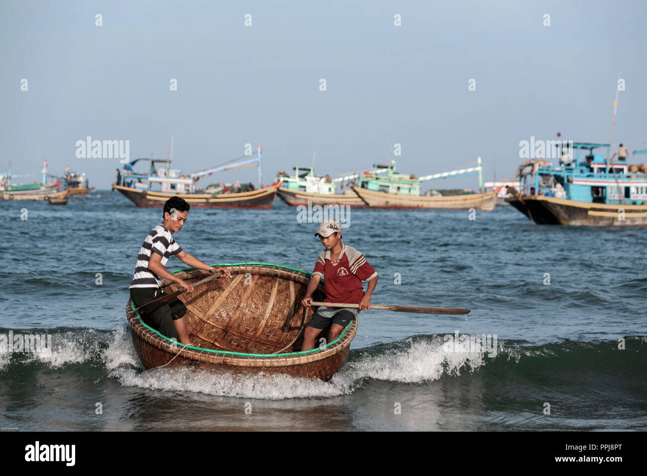 Dos jóvenes pescadores lanchas a su barco pesquero en Mui Ne, Vietnam Foto de stock