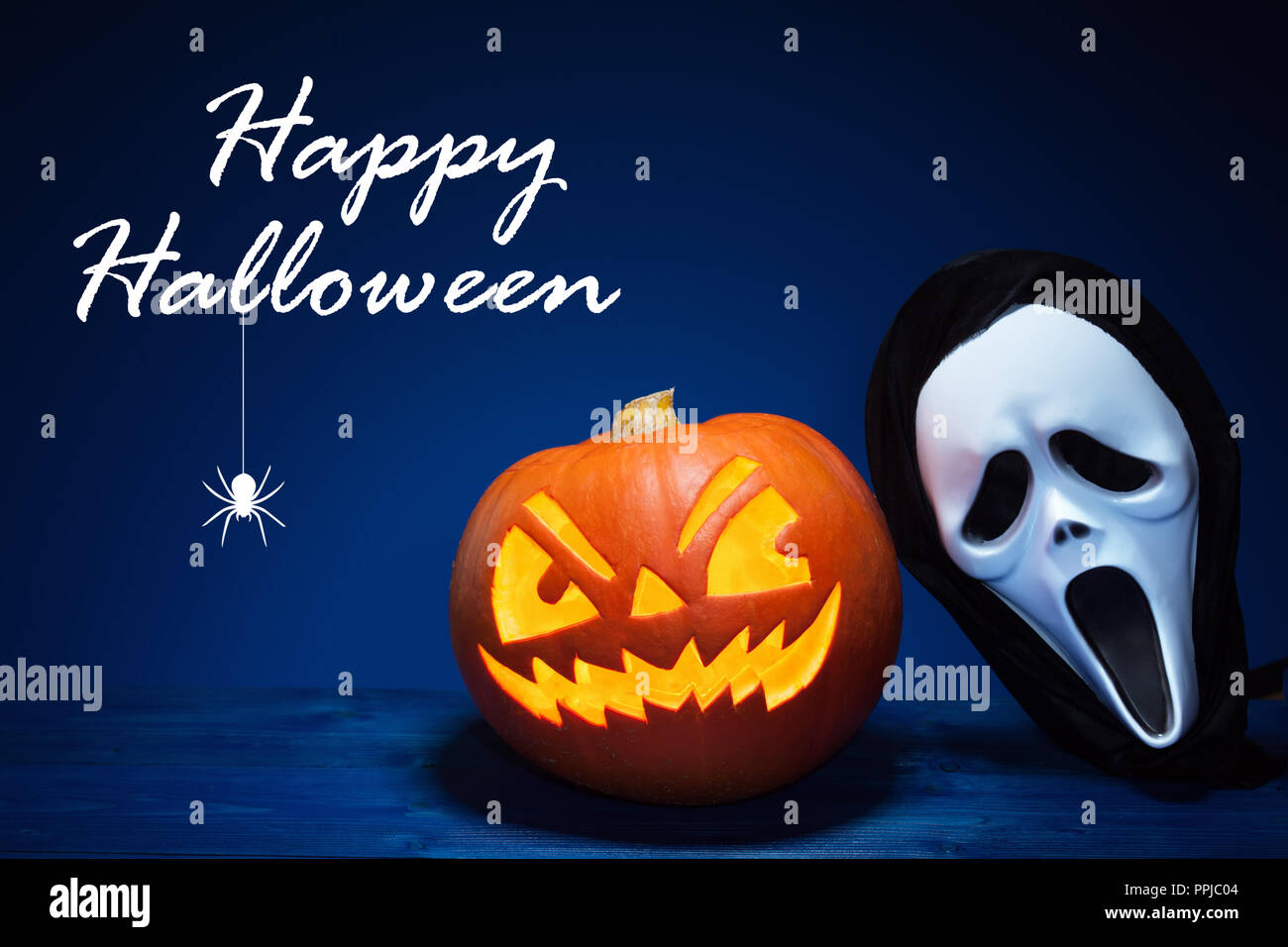 Halloween calabaza y máscara de texto sobre fondo azul oscuro. Foto de stock