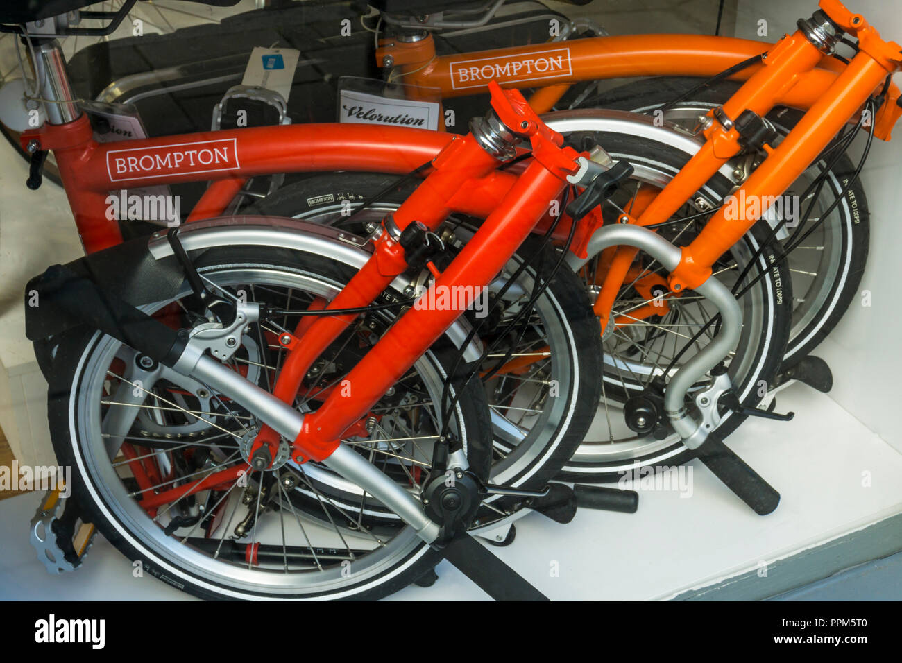 Las bicicletas plegables Brompton plegada en un espacio pequeño en un escaparate. Foto de stock