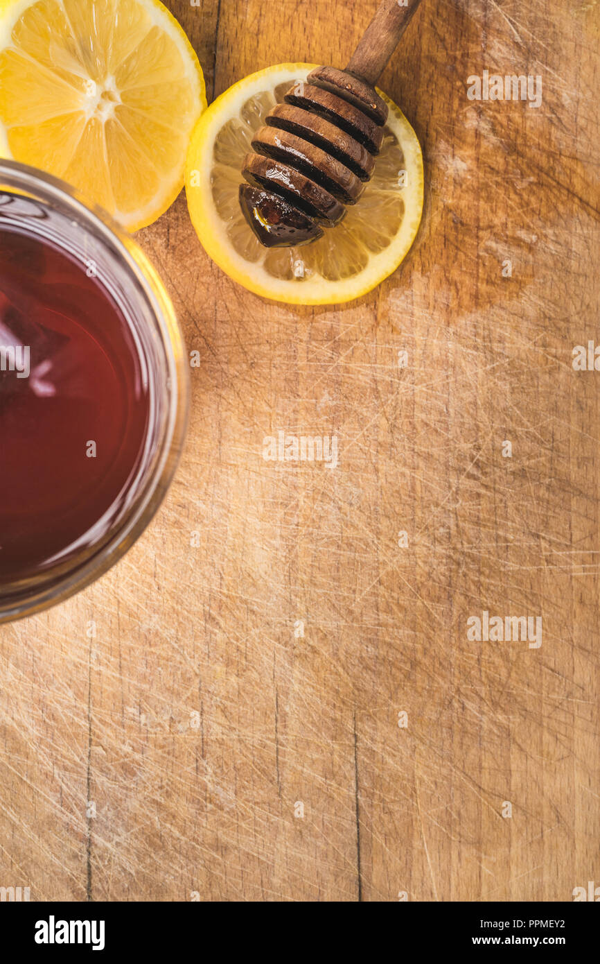 Tratamiento de frío y recursos naturales sobre fondo de madera. Té caliente con limón y miel orgánica. Foto de stock
