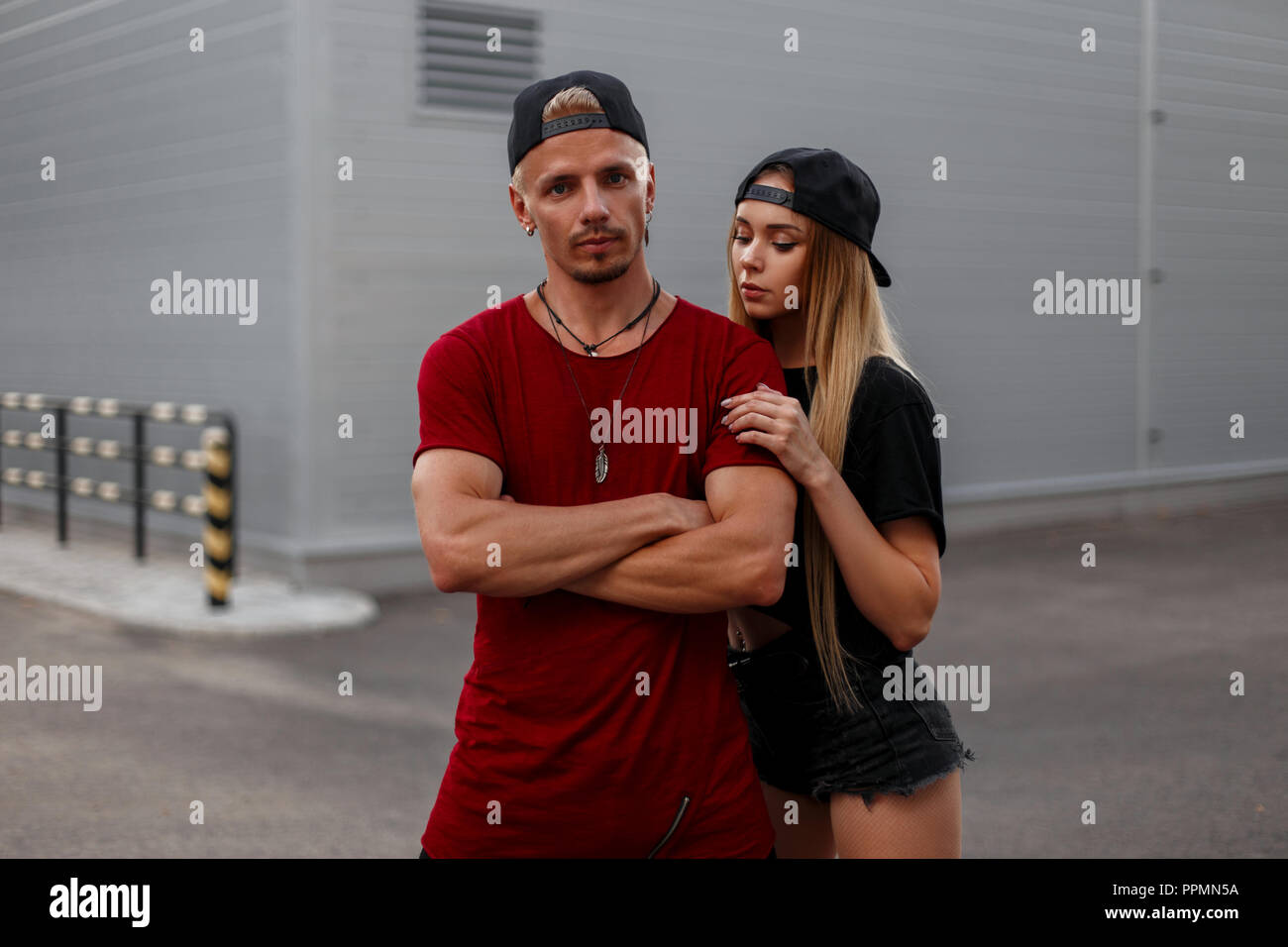 Elegante y hermosa joven pareja de gorras de béisbol en ropa de moda de pie  en la calle Fotografía de stock - Alamy