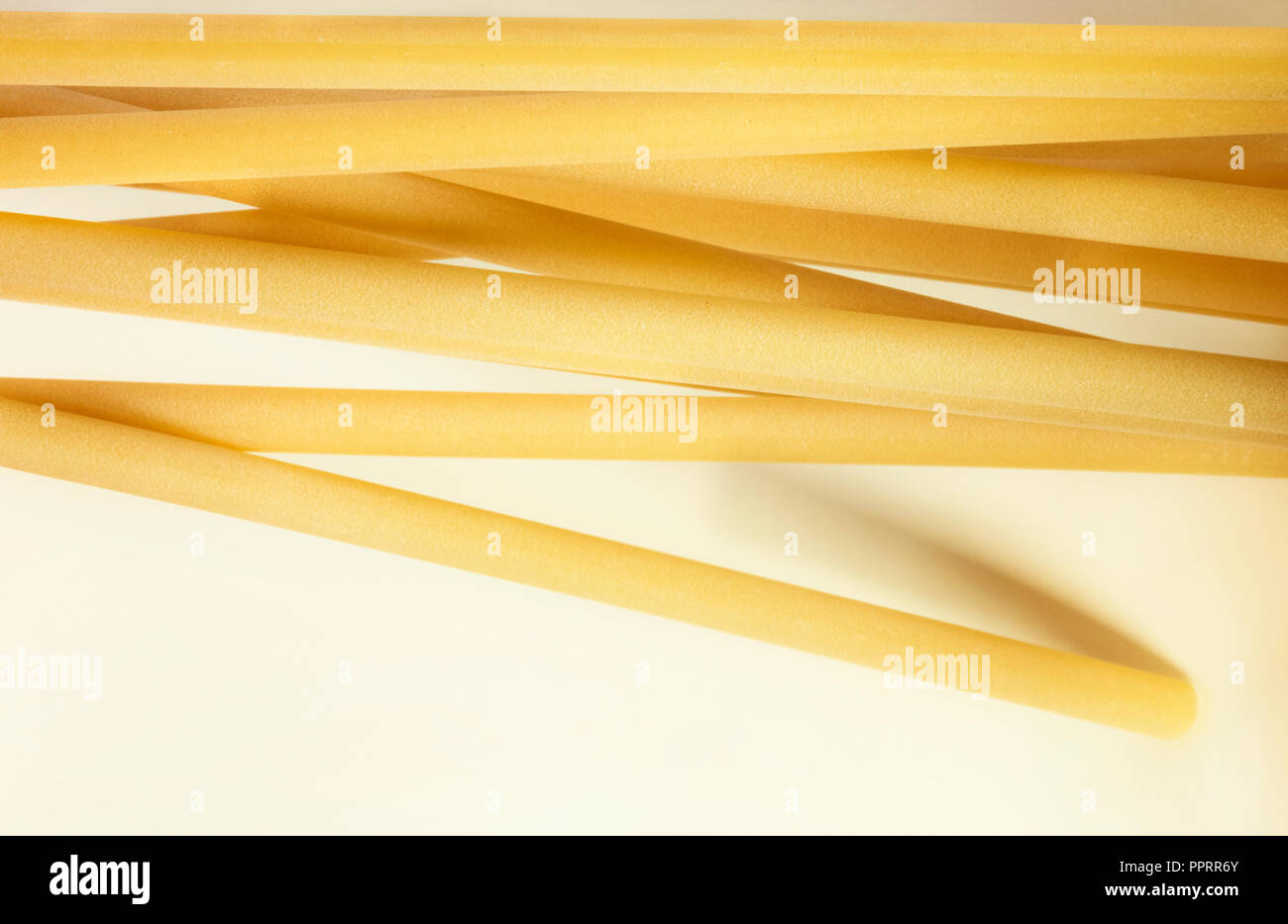 Un grupo de pasta italiana llamado ziti sobre un fondo blanco ,largo tubo de vacío con el lado liso ,composición horizontal Foto de stock