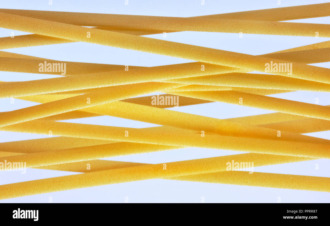 Un grupo de pasta italiana llamado linguine sobre un fondo claro ,plana larga pasta amarillo , efecto abstracto ,composición horizontal Foto de stock