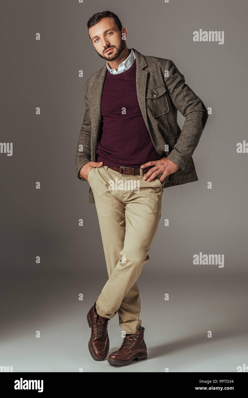 Apuesto hombre posando en otoño elegante chaqueta de tweed, sobre gris  Fotografía de stock - Alamy