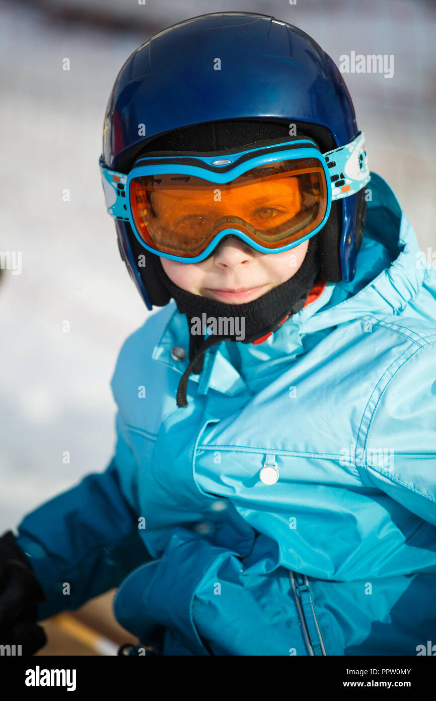 Una niña de gafas de esquí, un casco y un traje de pasear por las montañas.paseo nocturno en las montañas Foto de stock