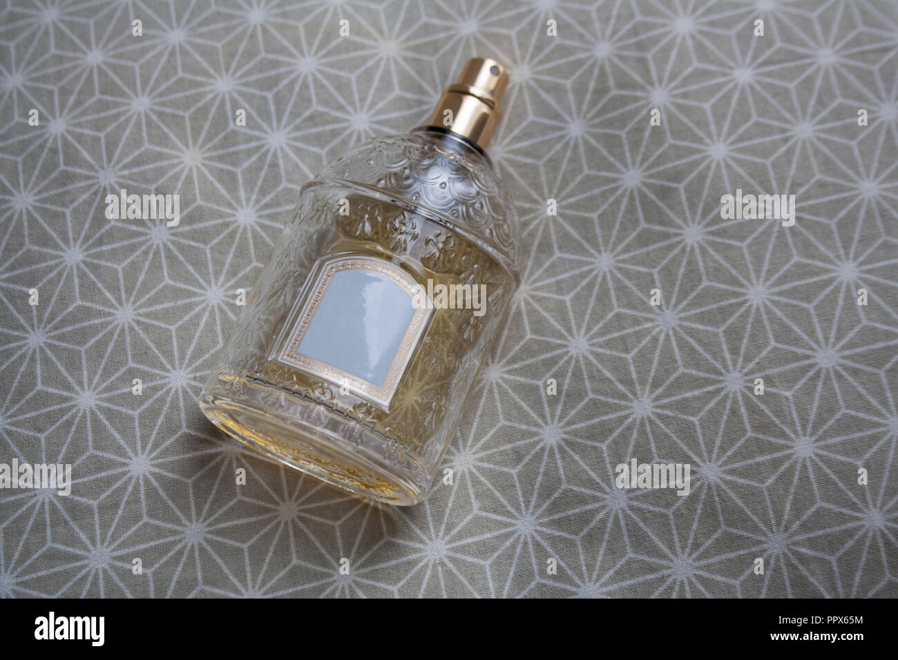 Frasco de perfume de vidrio transparente con alivio aislado en tejido  estampado beige Fotografía de stock - Alamy