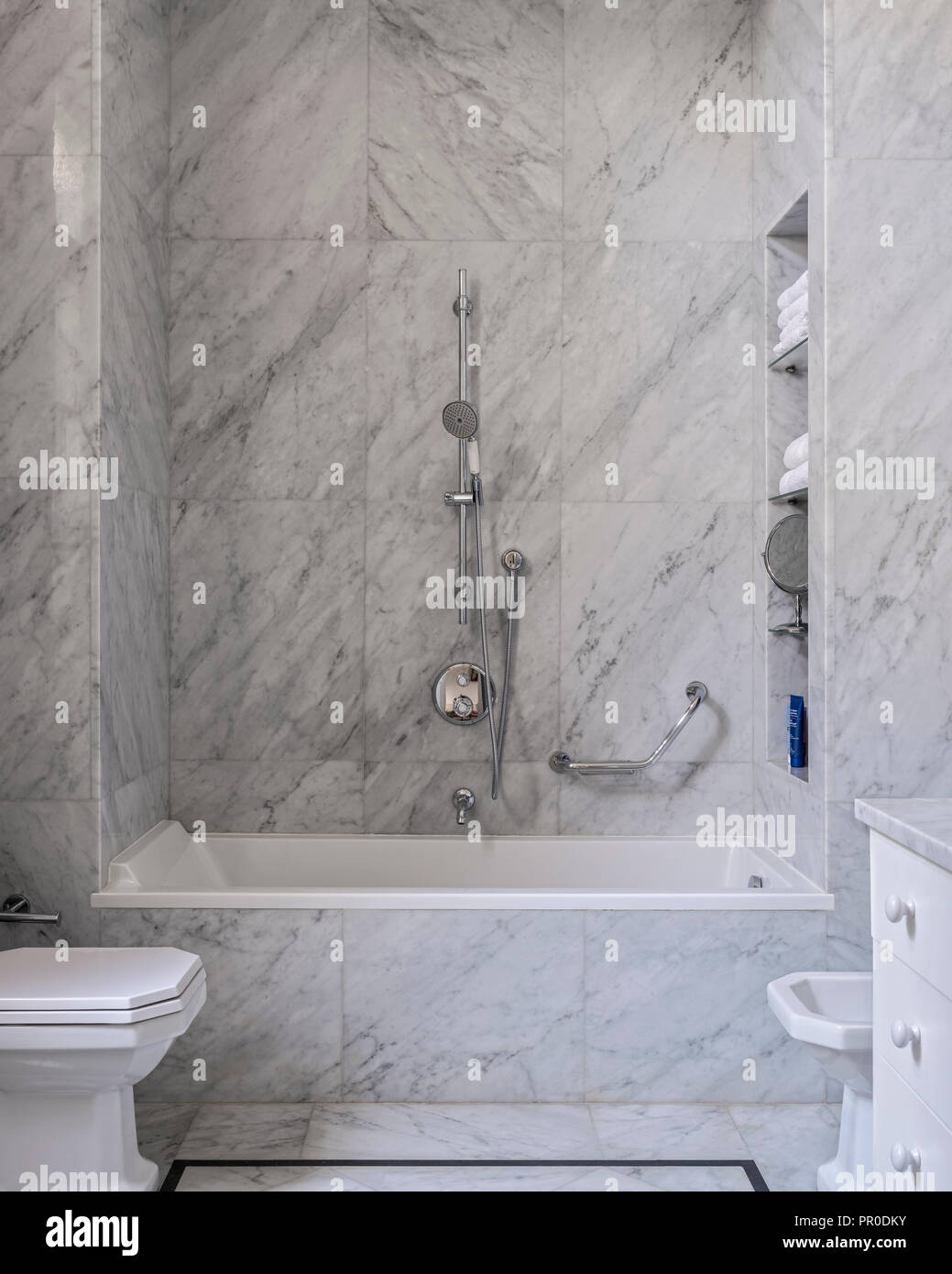 El moderno baño con baldosas de mármol blanco y gris. Foto de stock