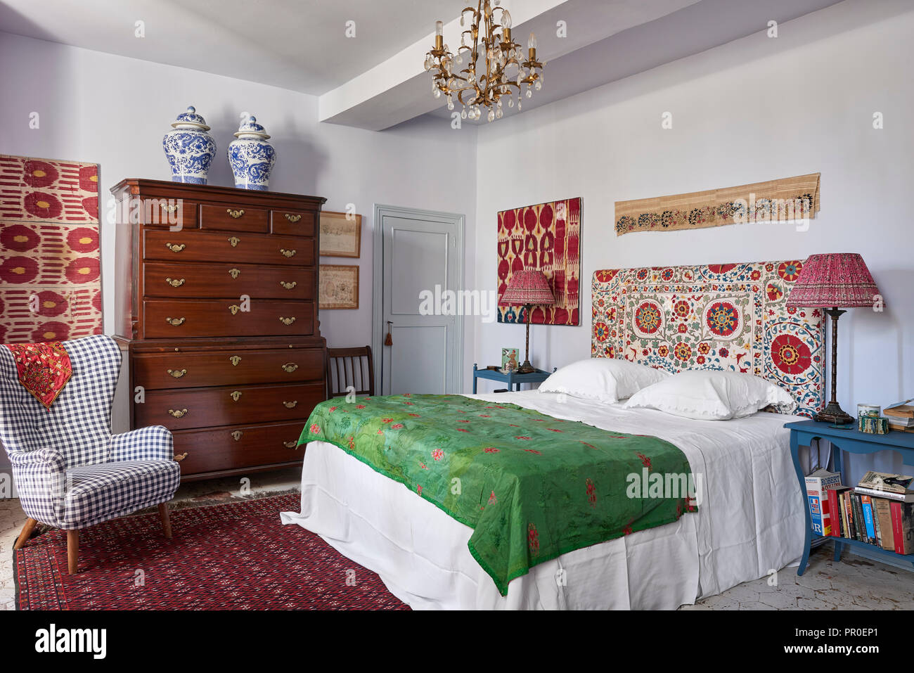 Antigua cama doble con cabecera de madera y el escalón, sillón tapizados en  dormitorio de invitados con suelos de madera de abeto manchada de aceite  dentro de la antigua casa de 1900
