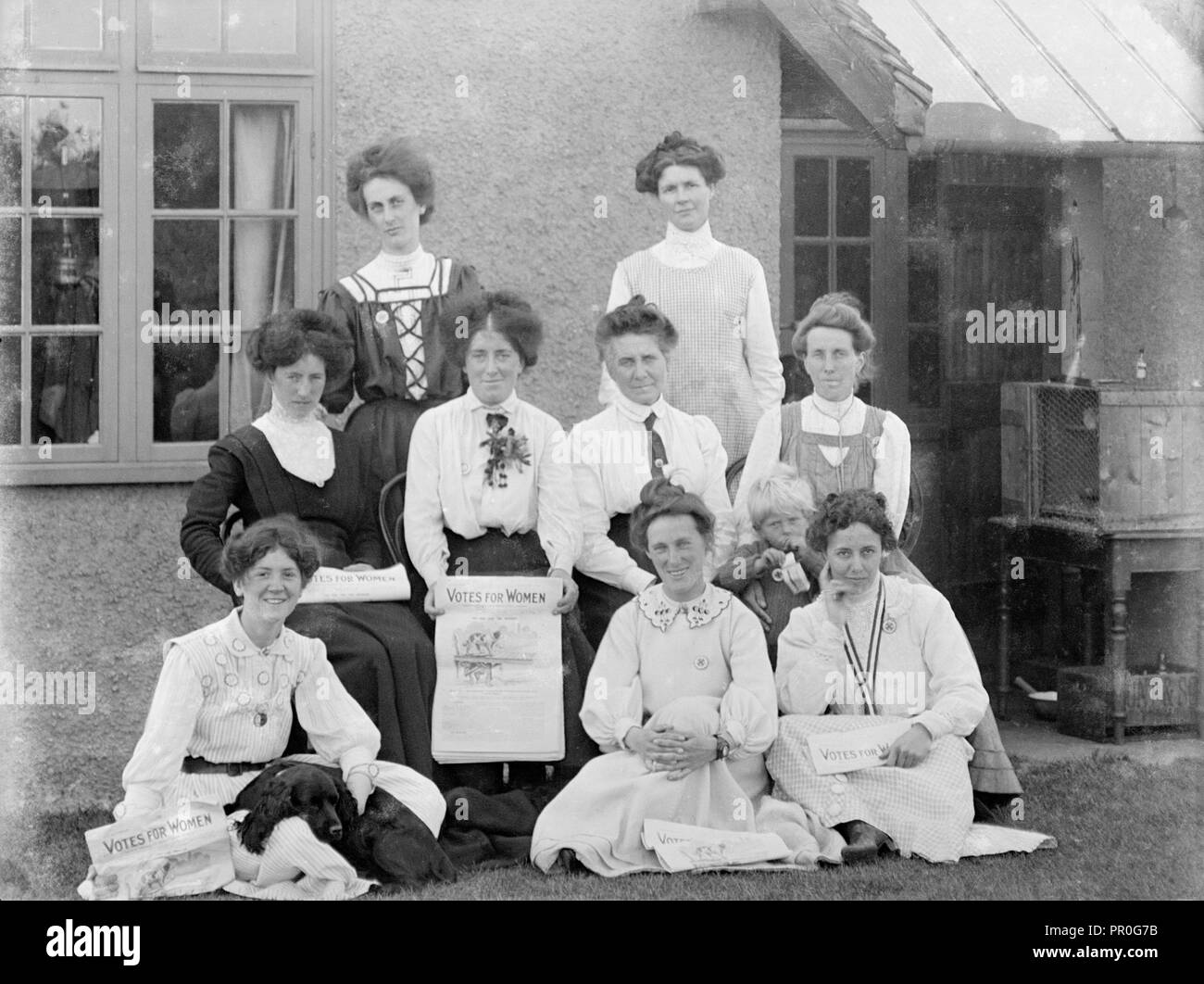 Grupo de 9 british suffragettes vistiendo WSPU insignias con el voto de la mujer afiche infantil y perro de septiembre de 1910 Emisión de papel Foto de stock