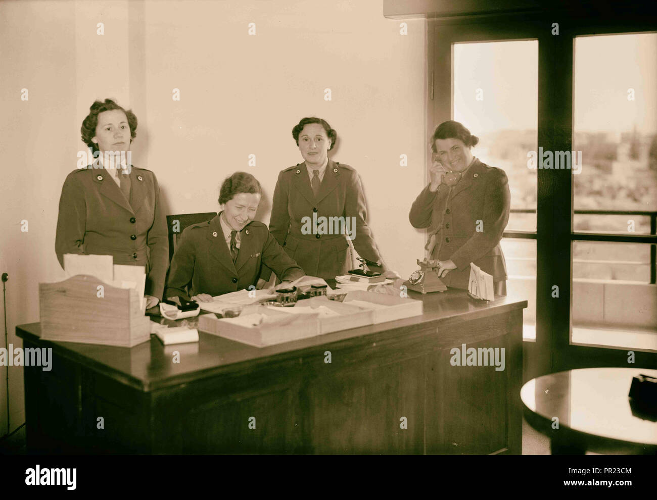 La Cruz Roja Británica y San Juan. Grupo de señoritas en El Dr. Stewart's desk. 1941, Oriente Medio, Israel Foto de stock