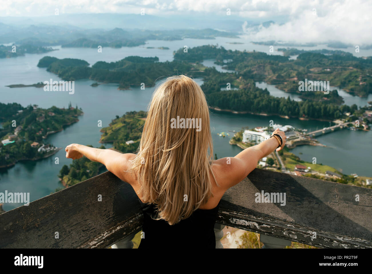 Mujer de detrás buscando en vistas de los lagos desde El Peñol de Guatapé (la roca). Guatape, Colombia. El estilo de vida, viajes wanderlust. Sep 2018 Foto de stock