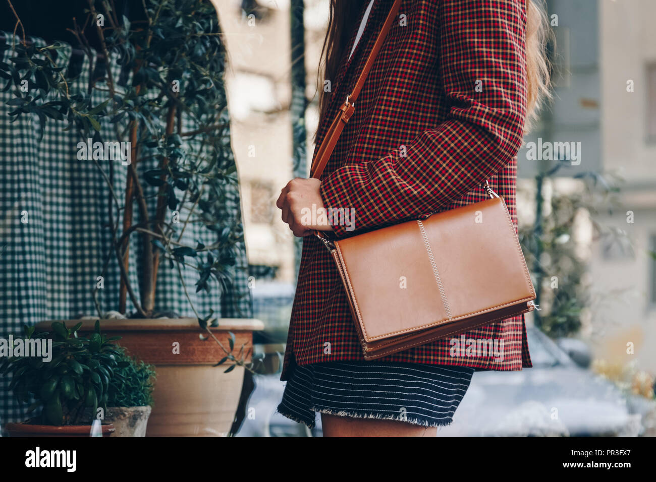 Street Style, atractiva mujer vistiendo una mini falda, verificar plaid  marrón lether blazer y un bolso de moda outfit perfecto para el otoño  Fotografía de stock - Alamy