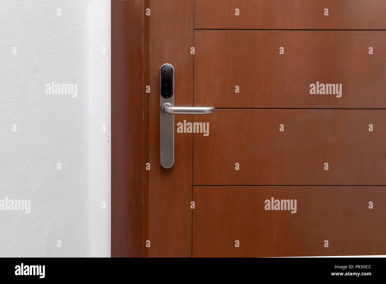 Cerca de una empuñadura de puerta de bloqueo de tarjeta en un hotel de lujo y una puerta con paneles de madera oscura contemporánea en el Caribe Foto de stock