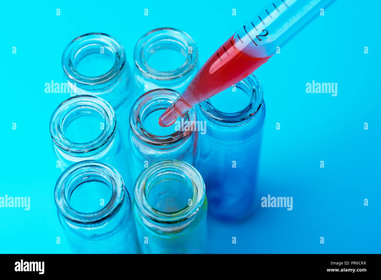 Tubos de ensayo sucio sobre fondo azul. La investigación en el laboratorio. Foto de stock