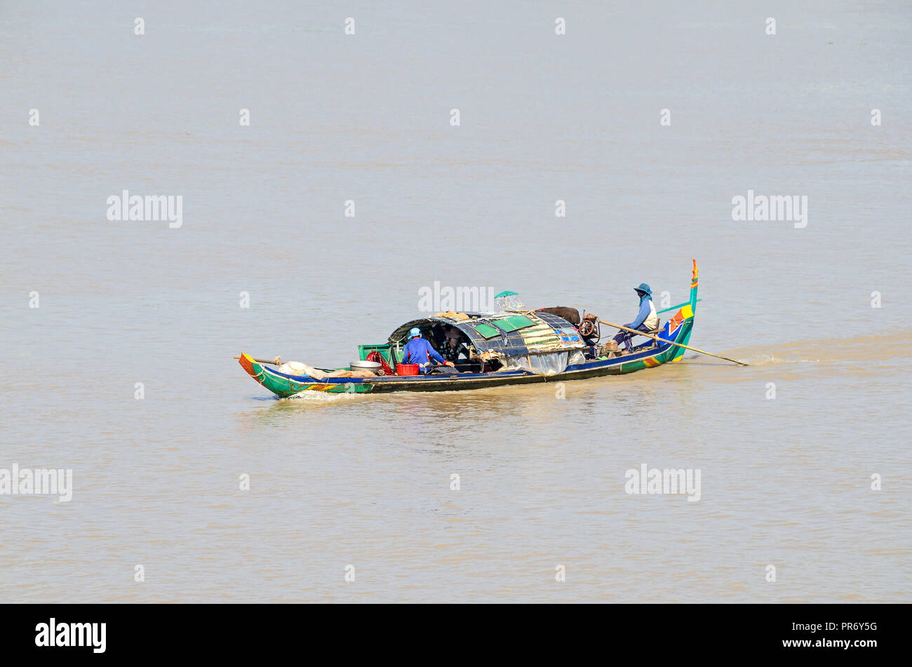 Phnom Penh, Camboya - Abril 9, 2018: típico del Mekong camboyano long tail boat y una familia de Boat People que viven en su casa flotante Foto de stock