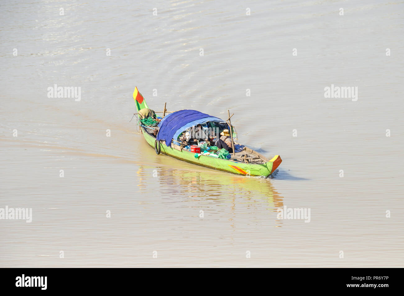 Phnom Penh, Camboya - Abril 9, 2018: típico del Mekong camboyano long tail boat con canopyand una familia de Boat People que viven en su casa flotante Foto de stock