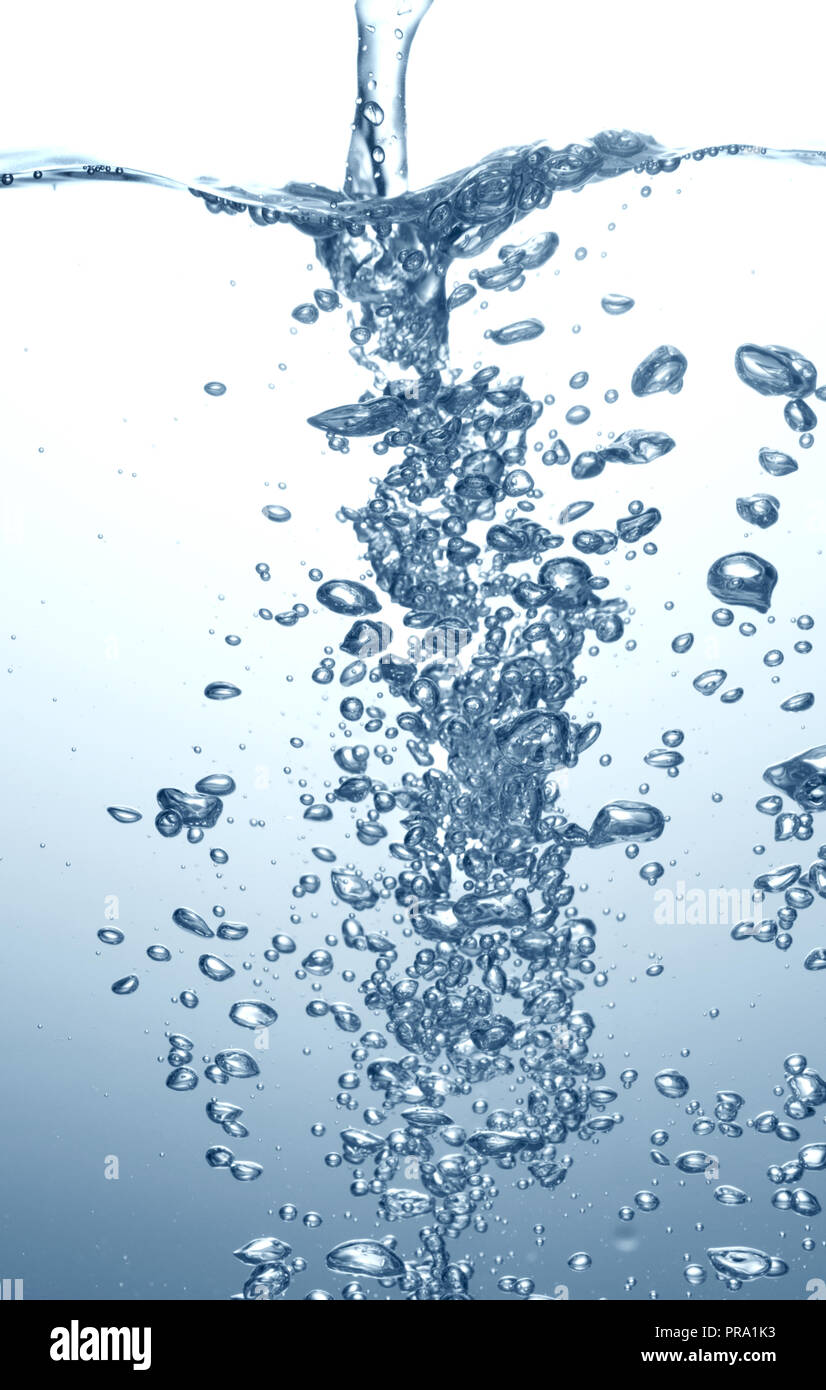 Agua Azul pura superficie con salpicaduras y burbujas de aire sobre fondo blanco. Foto de stock