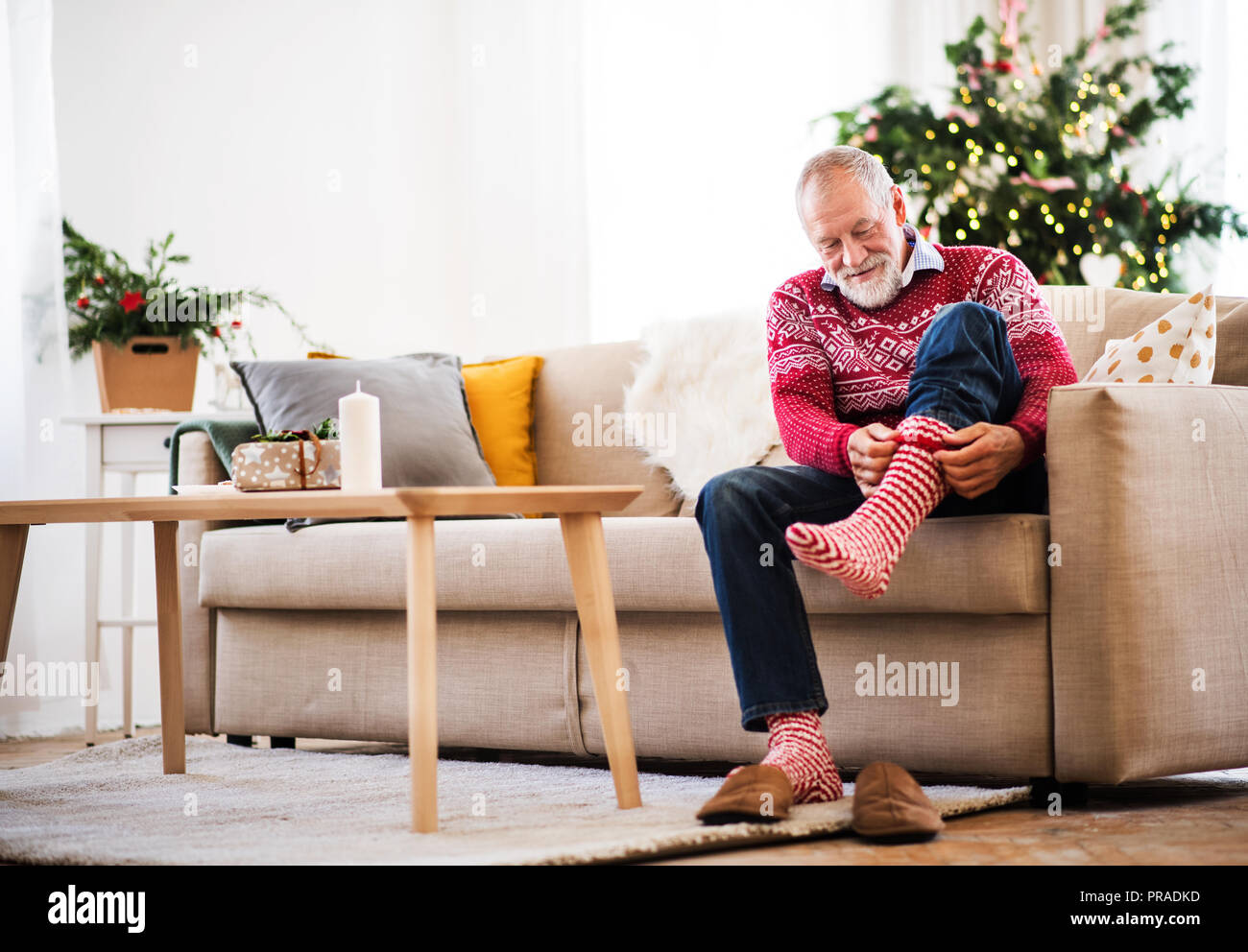 Un hombre senior poniendo los calcetines en la en el tiempo de Navidad Fotografía stock - Alamy