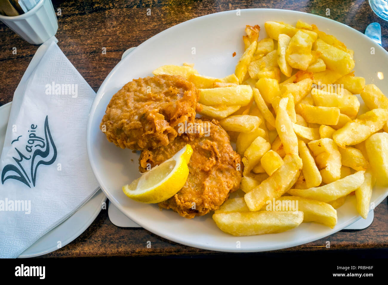 Magpie Cafe maltrecha pasteles de pescado y patatas fritas Foto de stock