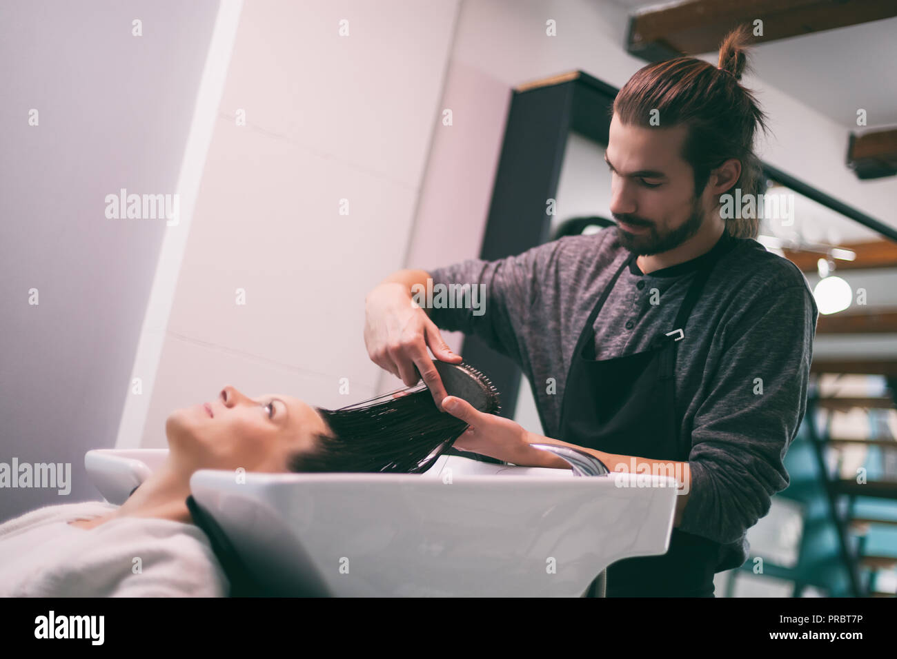 Mujer joven obteniendo nuevo peinado en el salón de peluquería profesional. Foto de stock