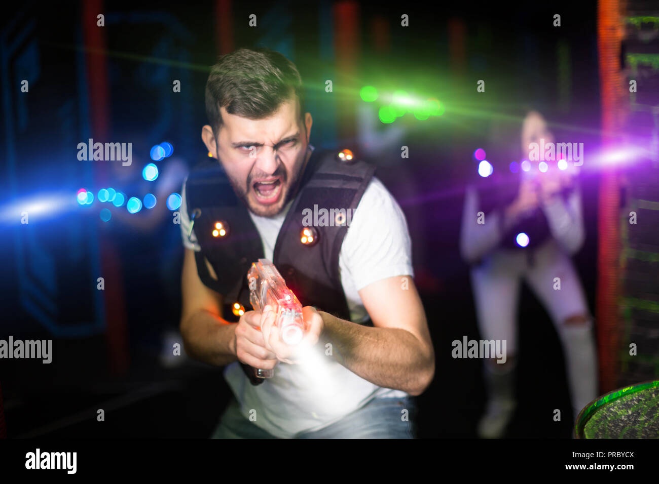 Retrato de emocionados guy laser tag jugador con pistola láser en  habitación con rayos luminosos Fotografía de stock - Alamy