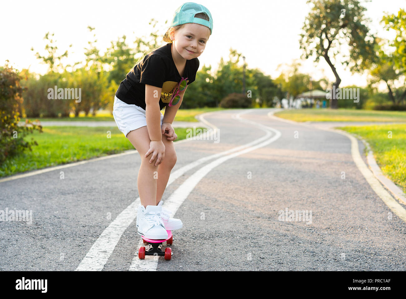 Niño de en verano skate park. Niña aprender montar en skate board. Deporte al aire libre para niños escolares y preescolares. Los niños skateboarding. Preescolar longboard. Niño patinando Fotografía