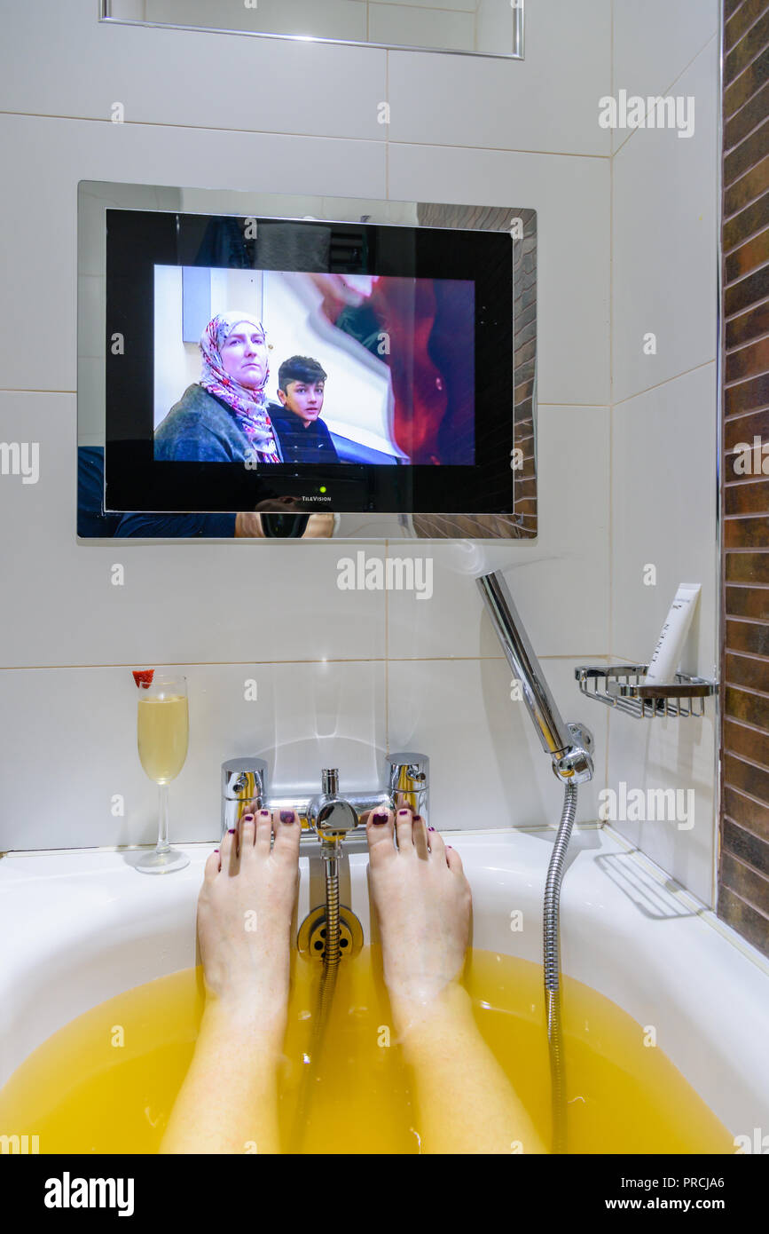 La televisión en la pared al final de un baño en un hotel. Foto de stock